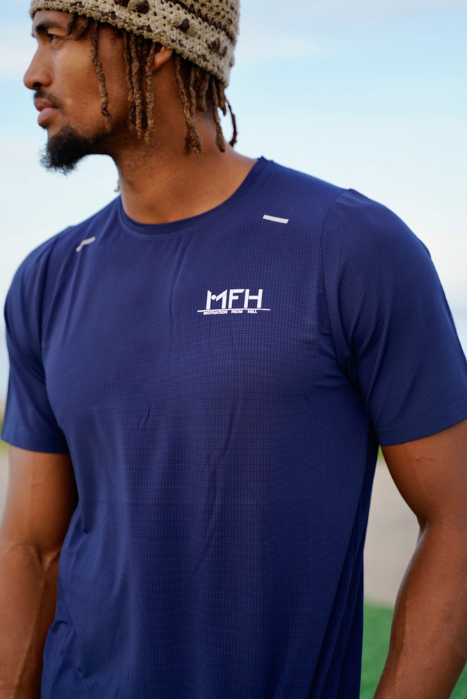 Træneren poserer iført blå t-shirt med MFH-logo.